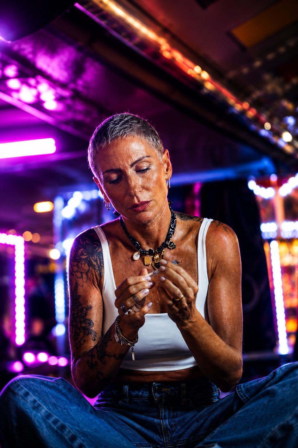 Donna che compone un gioiello Banda Amikette tra le luci del luna park
